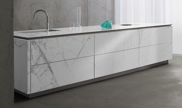 White marble island from SieMatic with glass ornaments and silver tap in concrete room